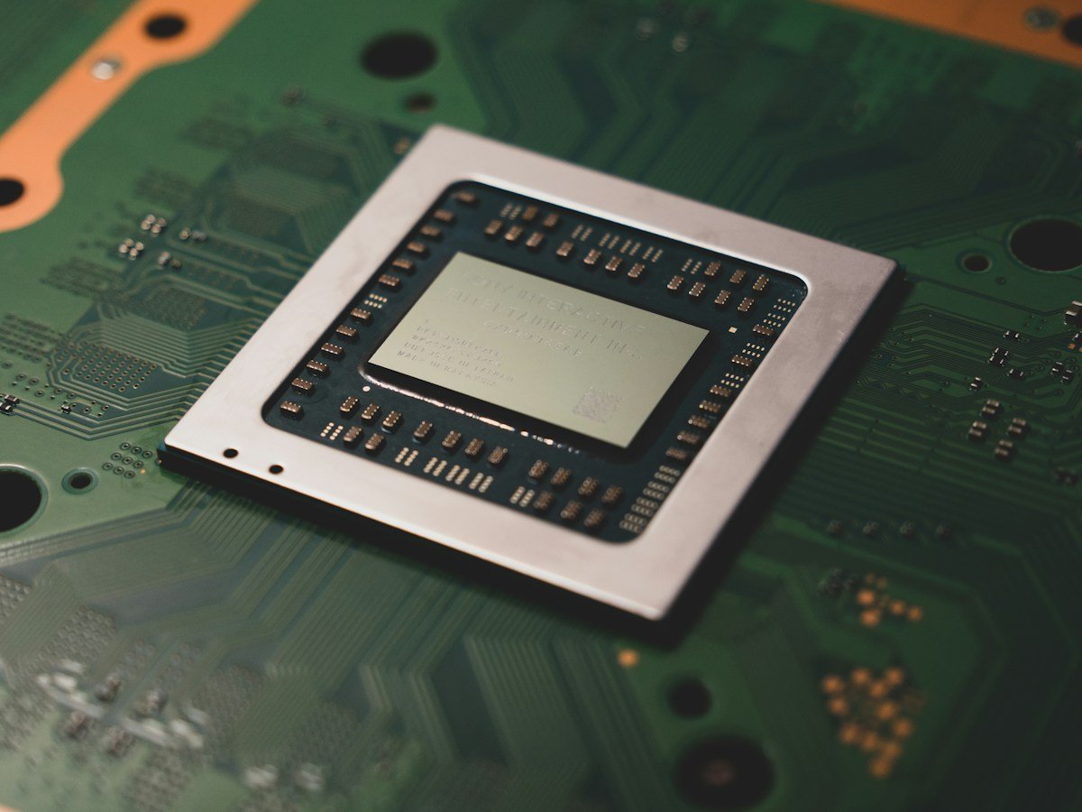 Close-up of an exposed processor chip mounted on a green circuit board.